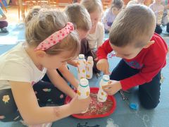 Dzieci tworzą grzechotkę z materiałów recyklingowych