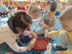 Dzieci tworzą grzechotkę z materiałów recyklingowych