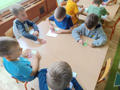 Dzieci wyklejają jabłka plasteliną 